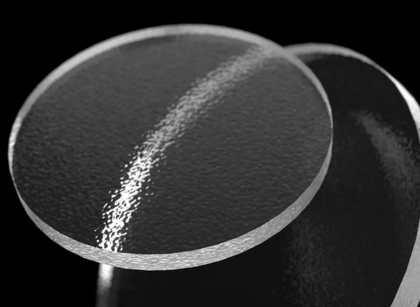 Two pieces of circular glass over a black background