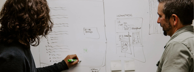 A man and women writing on a white board