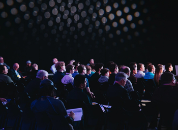 A crowd of people sitting and watching a presentation