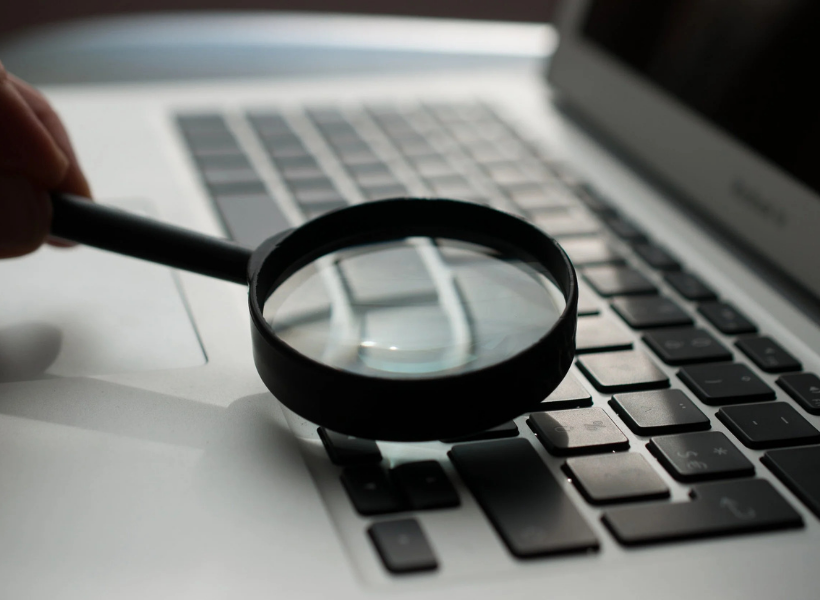 A magnifying glass hovering over a keyboard