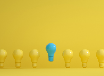 A blue-tinted lightbulb rises higher than the row of yellow lightbulbs it is included in.